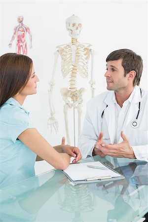 simsearch:400-07269643,k - Male doctor listening to patient with concentration at desk in medical office Fotografie stock - Microstock e Abbonamento, Codice: 400-07270855