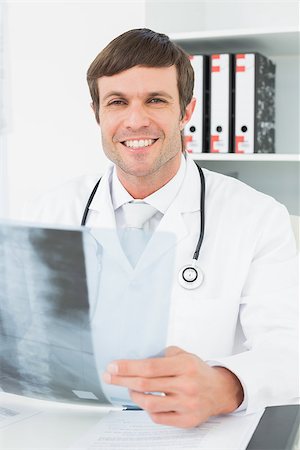 simsearch:400-07269250,k - Portrait of a smiling male doctor with x-ray picture of spine in the medical office Stock Photo - Budget Royalty-Free & Subscription, Code: 400-07270903