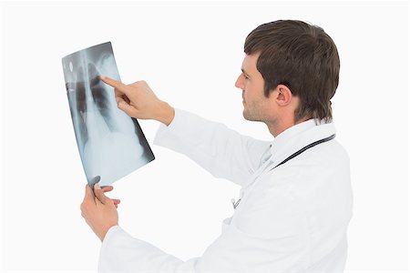 simsearch:400-07269250,k - Side view of a concentrated male doctor looking at x-ray picture of lungs over white background Stock Photo - Budget Royalty-Free & Subscription, Code: 400-07270915