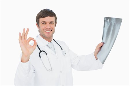 simsearch:400-04552598,k - Portrait of a smiling male doctor holding an x-ray picture of lungs over white background Foto de stock - Super Valor sin royalties y Suscripción, Código: 400-07270927