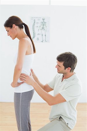 Side view of a male physiotherapist examining woman's back in the medical office Stockbilder - Microstock & Abonnement, Bildnummer: 400-07271049