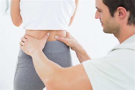 Close-up mid section of a physiotherapist examining woman's back in the medical office Photographie de stock - Aubaine LD & Abonnement, Code: 400-07271065