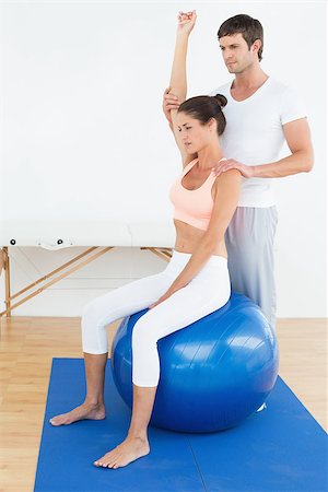 simsearch:400-07232187,k - Young woman sitting on yoga ball while working with a physical therapist Foto de stock - Royalty-Free Super Valor e Assinatura, Número: 400-07271481