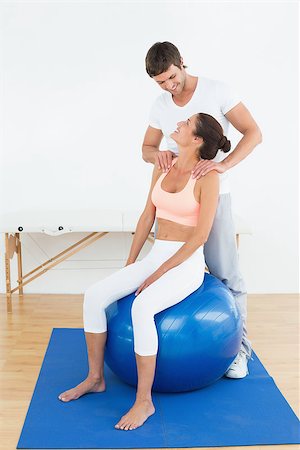 simsearch:400-07232187,k - Young woman sitting on yoga ball while working with a physical therapist Foto de stock - Royalty-Free Super Valor e Assinatura, Número: 400-07271490
