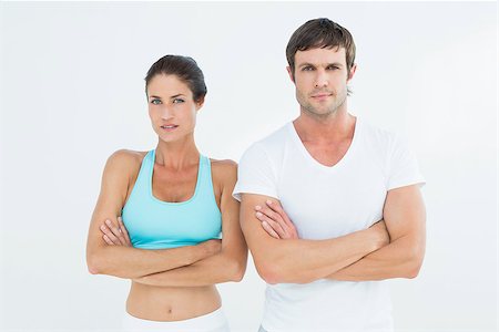 simsearch:649-07239579,k - Portrait of a fit young couple with arms crossed standing over white background Foto de stock - Super Valor sin royalties y Suscripción, Código: 400-07271587