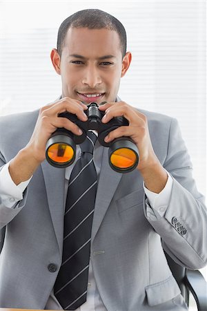 simsearch:400-07266908,k - Portrait of a confident young businessman with binoculars in the office Photographie de stock - Aubaine LD & Abonnement, Code: 400-07272728