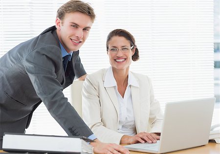 simsearch:400-05663929,k - Portrait of a confident smiling business couple with laptop in a bright office Stock Photo - Budget Royalty-Free & Subscription, Code: 400-07272760