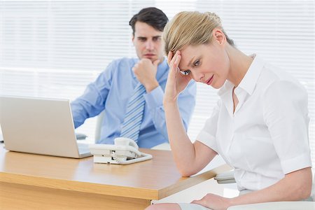 simsearch:400-05663929,k - Upset young businesswoman with man working on laptop at office desk Stock Photo - Budget Royalty-Free & Subscription, Code: 400-07272788