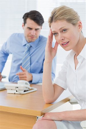 simsearch:400-05663929,k - Upset young businesswoman with man working on laptop at office desk Stock Photo - Budget Royalty-Free & Subscription, Code: 400-07272790