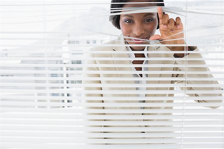 simsearch:400-07266908,k - Portrait of a young businesswoman peeking through blinds in office Photographie de stock - Aubaine LD & Abonnement, Code: 400-07272844