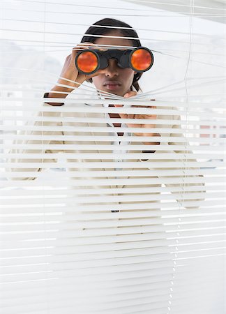 Serious young businesswoman peeking with binoculars through blinds in the office Stock Photo - Budget Royalty-Free & Subscription, Code: 400-07272842