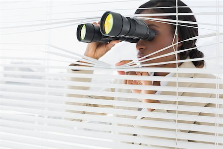 Serious young businesswoman peeking with binoculars through blinds in the office Stock Photo - Budget Royalty-Free & Subscription, Code: 400-07272843