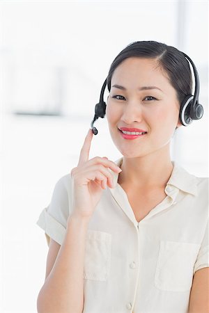 female agent - Portrait of a beautiful smiling female executive with headset in a bright office Stock Photo - Budget Royalty-Free & Subscription, Code: 400-07272923