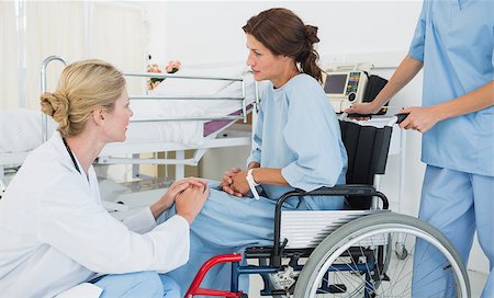 Side view of a doctor talking to a female patient in wheelchair at the hospital Fotografie stock - Microstock e Abbonamento, Codice: 400-07273174