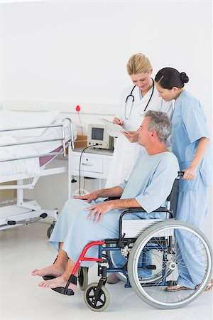 Side view of a doctor talking to a male patient in wheelchair at the hospital Fotografie stock - Microstock e Abbonamento, Codice: 400-07273229