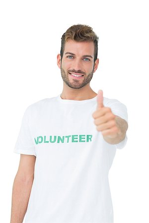 simsearch:400-07273307,k - Portrait of a happy male volunteer gesturing thumbs up over white background Stockbilder - Microstock & Abonnement, Bildnummer: 400-07273250