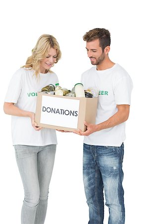 simsearch:400-07273307,k - Smiling young couple carrying donation box over white background Stockbilder - Microstock & Abonnement, Bildnummer: 400-07273281