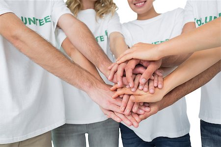 simsearch:400-07273325,k - Closeup mid section of volunteers with hands together over white background Foto de stock - Royalty-Free Super Valor e Assinatura, Número: 400-07273313