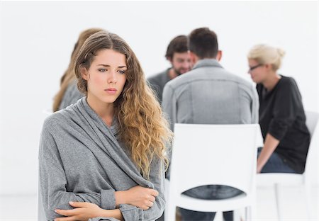 simsearch:400-07273405,k - Group therapy in session sitting in a circle with therapist while woman in foreground Fotografie stock - Microstock e Abbonamento, Codice: 400-07273430
