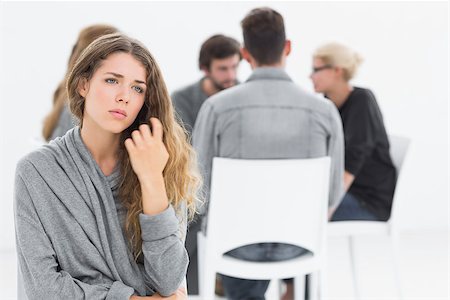 simsearch:400-07273405,k - Group therapy in session sitting in a circle with therapist while woman in foreground Fotografie stock - Microstock e Abbonamento, Codice: 400-07273431
