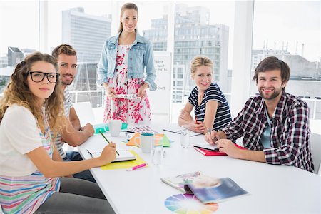 simsearch:400-07273325,k - Young casual business people sitting around conference table in a bright office Foto de stock - Royalty-Free Super Valor e Assinatura, Número: 400-07273450