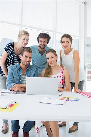 simsearch:400-07273325,k - Young casual business people using laptop together in a bright office Foto de stock - Royalty-Free Super Valor e Assinatura, Número: 400-07273475