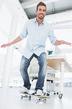 skateboard business - Full length of a happy young man skateboarding in a bright creative office Stock Photo - Budget Royalty-Free & Subscription, Code: 400-07273506