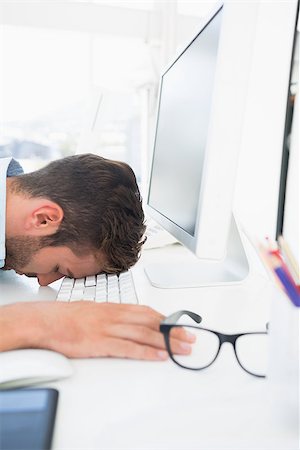 simsearch:400-07466593,k - Side view of a male artist with head resting on keyboard in the office Stock Photo - Budget Royalty-Free & Subscription, Code: 400-07273531