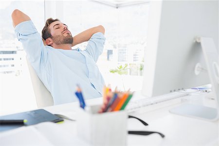 Relaxed casual young man resting with hands behind head in a bright office Stock Photo - Budget Royalty-Free & Subscription, Code: 400-07273532