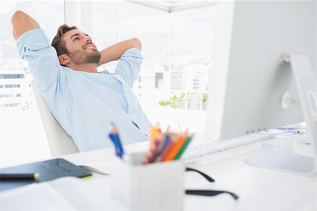 Relaxed casual young man resting with hands behind head in a bright office Stock Photo - Budget Royalty-Free & Subscription, Code: 400-07273533