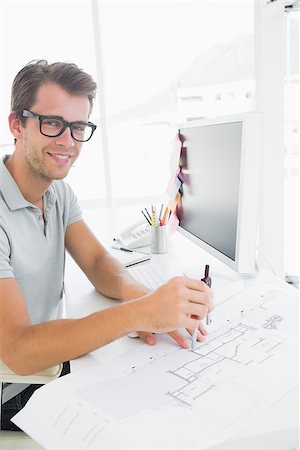Side view of a smiling young man using compass on design Photographie de stock - Aubaine LD & Abonnement, Code: 400-07273668