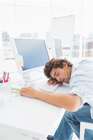 Young casual businessman resting with head over keyboard at desk in the office Stock Photo - Budget Royalty-Free & Subscription, Code: 400-07273803