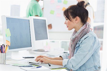 people standing behind a table - Side view of an artist using computer with colleagues behind at the office Stock Photo - Budget Royalty-Free & Subscription, Code: 400-07273922