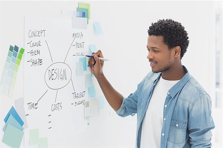 professionals whiteboard - Smiling male artist with pen standing in front of whiteboard Stock Photo - Budget Royalty-Free & Subscription, Code: 400-07273971