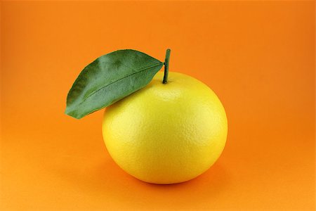 Ripe appetizing grapefruit with leaf on orange background. Stock Photo - Budget Royalty-Free & Subscription, Code: 400-07288215