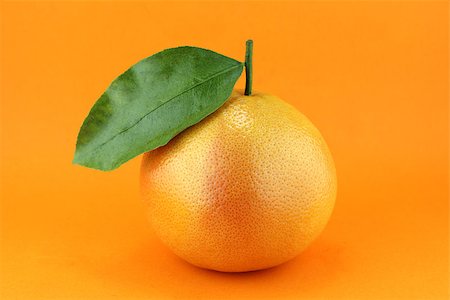 Ripe appetizing grapefruit with leaf on orange background. Stock Photo - Budget Royalty-Free & Subscription, Code: 400-07288216