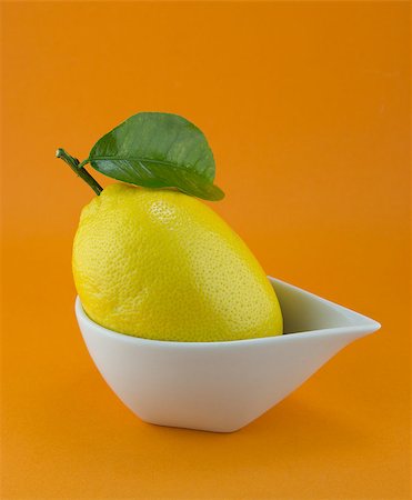 simsearch:824-07562806,k - yellow ripe lemon with leaf over the orange background Photographie de stock - Aubaine LD & Abonnement, Code: 400-07289167