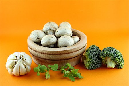 simsearch:400-07244181,k - button mushrooms in wooden bowl with garlic, parsley and broccoli on orange background. Foto de stock - Super Valor sin royalties y Suscripción, Código: 400-07289304
