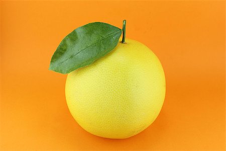 Ripe appetizing grapefruit with leaf on orange background. Stock Photo - Budget Royalty-Free & Subscription, Code: 400-07289334
