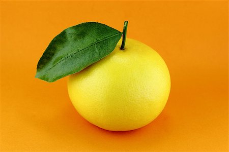 Ripe appetizing grapefruit with leaf on orange background. Stock Photo - Budget Royalty-Free & Subscription, Code: 400-07289485