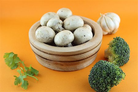 simsearch:400-07244181,k - button mushrooms in wooden bowl with garlic, parsley and broccoli on orange background. Foto de stock - Super Valor sin royalties y Suscripción, Código: 400-07289554