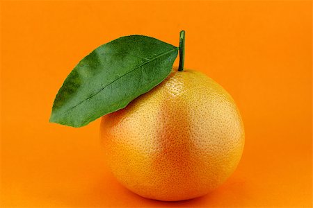 Ripe appetizing grapefruit with leaf on orange background. Stock Photo - Budget Royalty-Free & Subscription, Code: 400-07289637