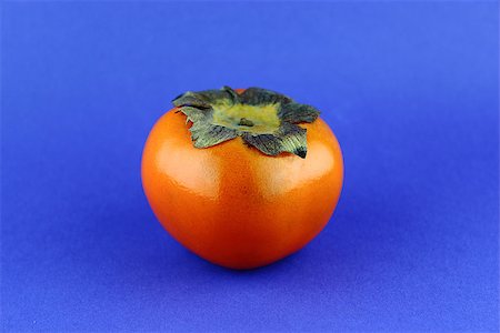 simsearch:400-07289954,k - persimmon fruit isolated on blue background. Foto de stock - Royalty-Free Super Valor e Assinatura, Número: 400-07289699