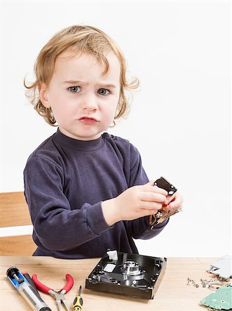 child repairing computer part. studio shot in light grey background Stock Photo - Budget Royalty-Free & Subscription, Code: 400-07294038