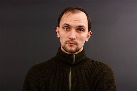 pzromashka (artist) - young man in an old sweater on a dark background. studio portrait Foto de stock - Royalty-Free Super Valor e Assinatura, Número: 400-07294042