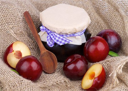 Arrangement of Jar of Plum Jam with Wooden Spoon,  Ripe Purple Plums Full Body and Halves closeup on Burlap background Stock Photo - Budget Royalty-Free & Subscription, Code: 400-07295165