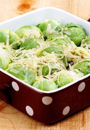 simsearch:400-07625359,k - Delicious Homemade Brussels Sprouts Casserole in Brown Polka Dot Bowl with Grated Cheese and Spices closeup on Wooden background Photographie de stock - Aubaine LD & Abonnement, Code: 400-07295635