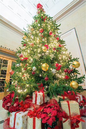 simsearch:400-07107254,k - Christmas Tree Decoration with Bokeh Lights Ornaments Ribbons Poinsettia and Presents Under the Tree Tall Perspective Photographie de stock - Aubaine LD & Abonnement, Code: 400-07296375