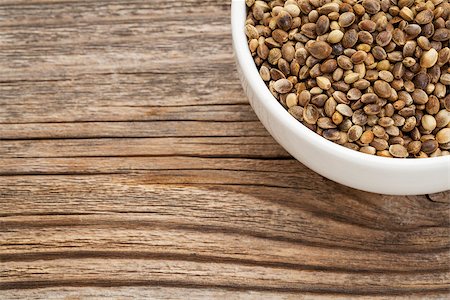 simsearch:400-07300783,k - whole hemp seeds in a small bowl on a grained wood Stockbilder - Microstock & Abonnement, Bildnummer: 400-07297317