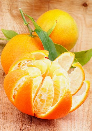 simsearch:400-08012355,k - Fresh Ripe Tangerine with Segments and Citrus Peel and Two Full Body with Leafs closeup on Wooden background Photographie de stock - Aubaine LD & Abonnement, Code: 400-07297344